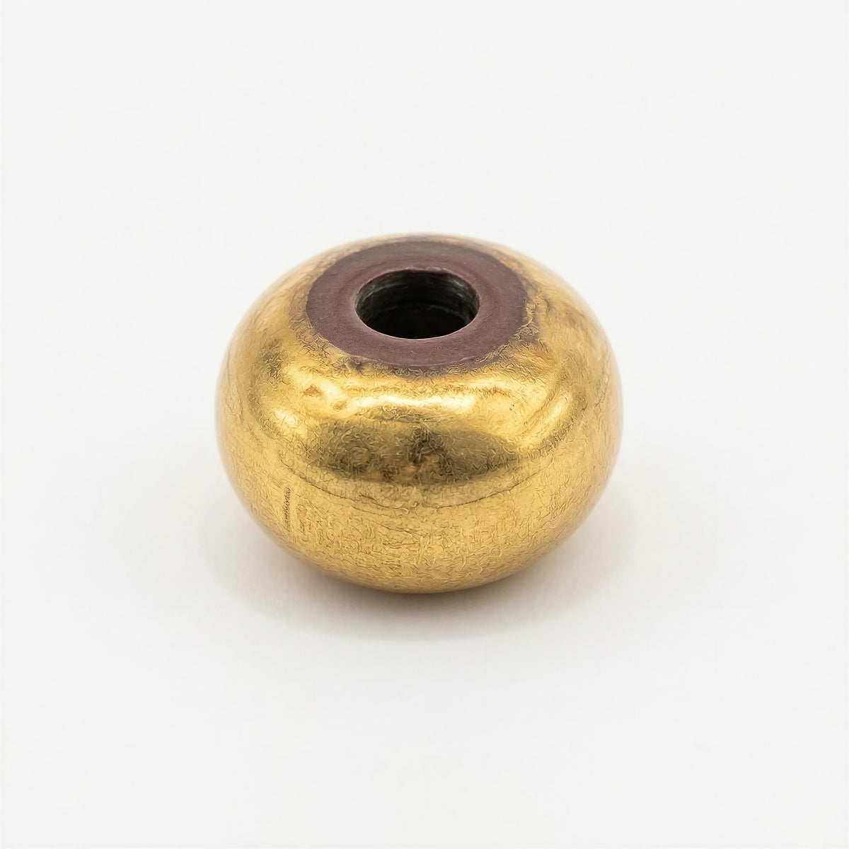 Close-up of a single gold-toned bead with a smooth, rounded oval shape and a textured finish, part of The Essential Collection - 8mm Aurea Ovalis handcrafted jewelry.